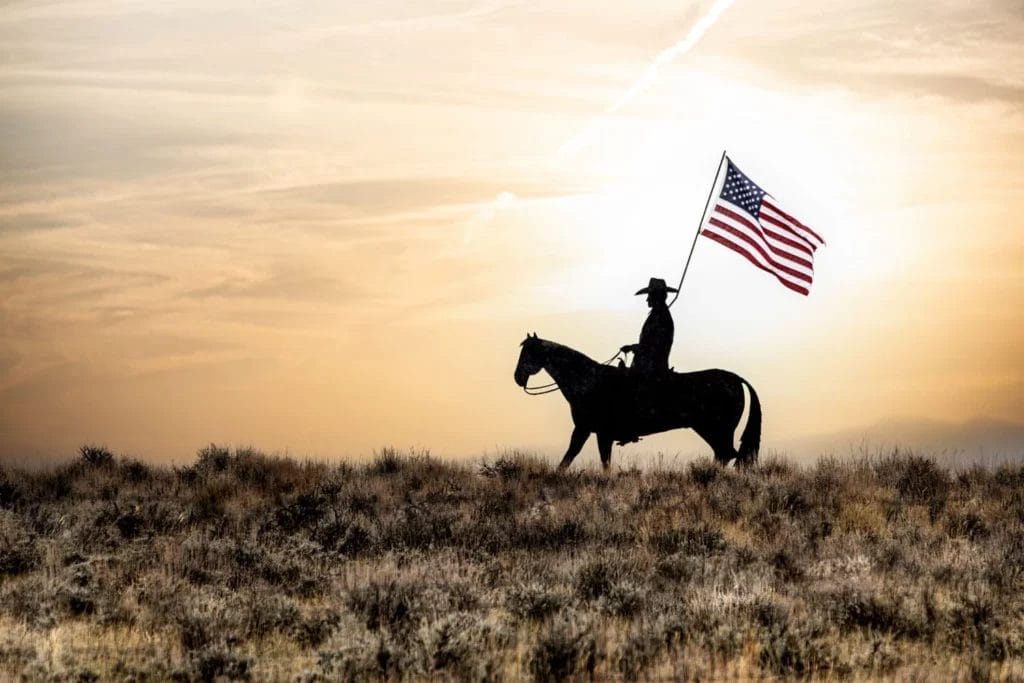 Cowboy on Horse with American Flag wearing Cowboy Boots